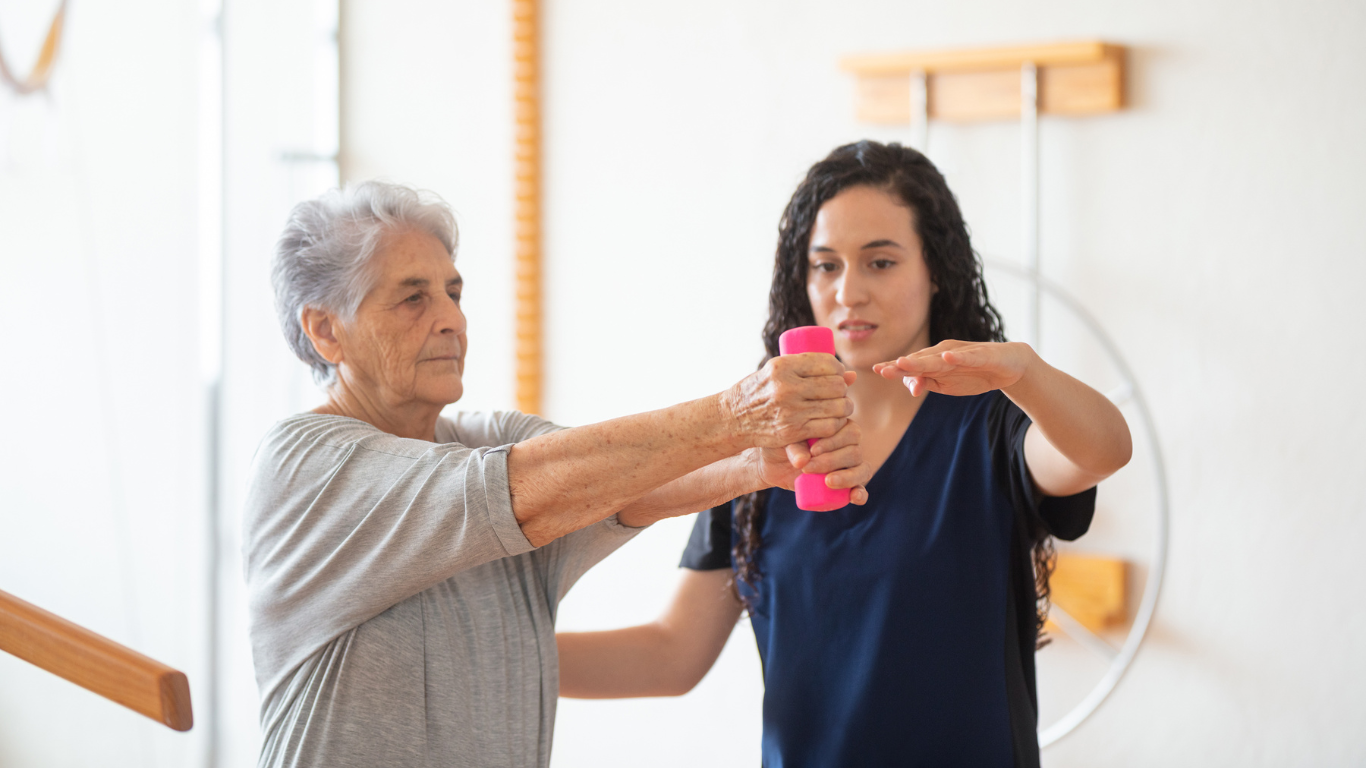 caregiver assisting old lady in her physical therapy